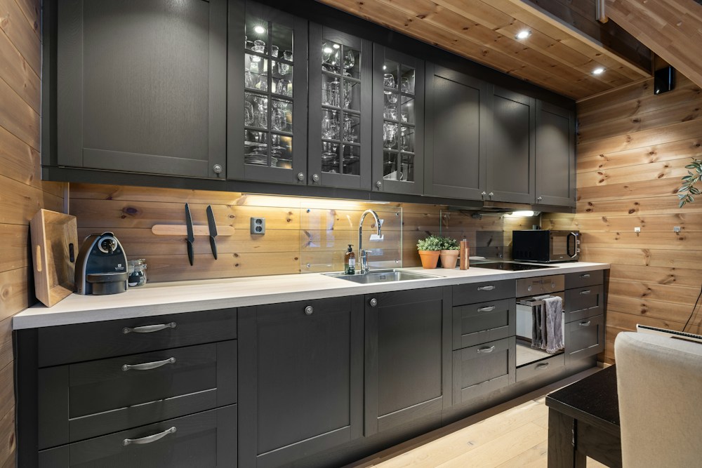 A kitchen with timber walls and dark cabinetry