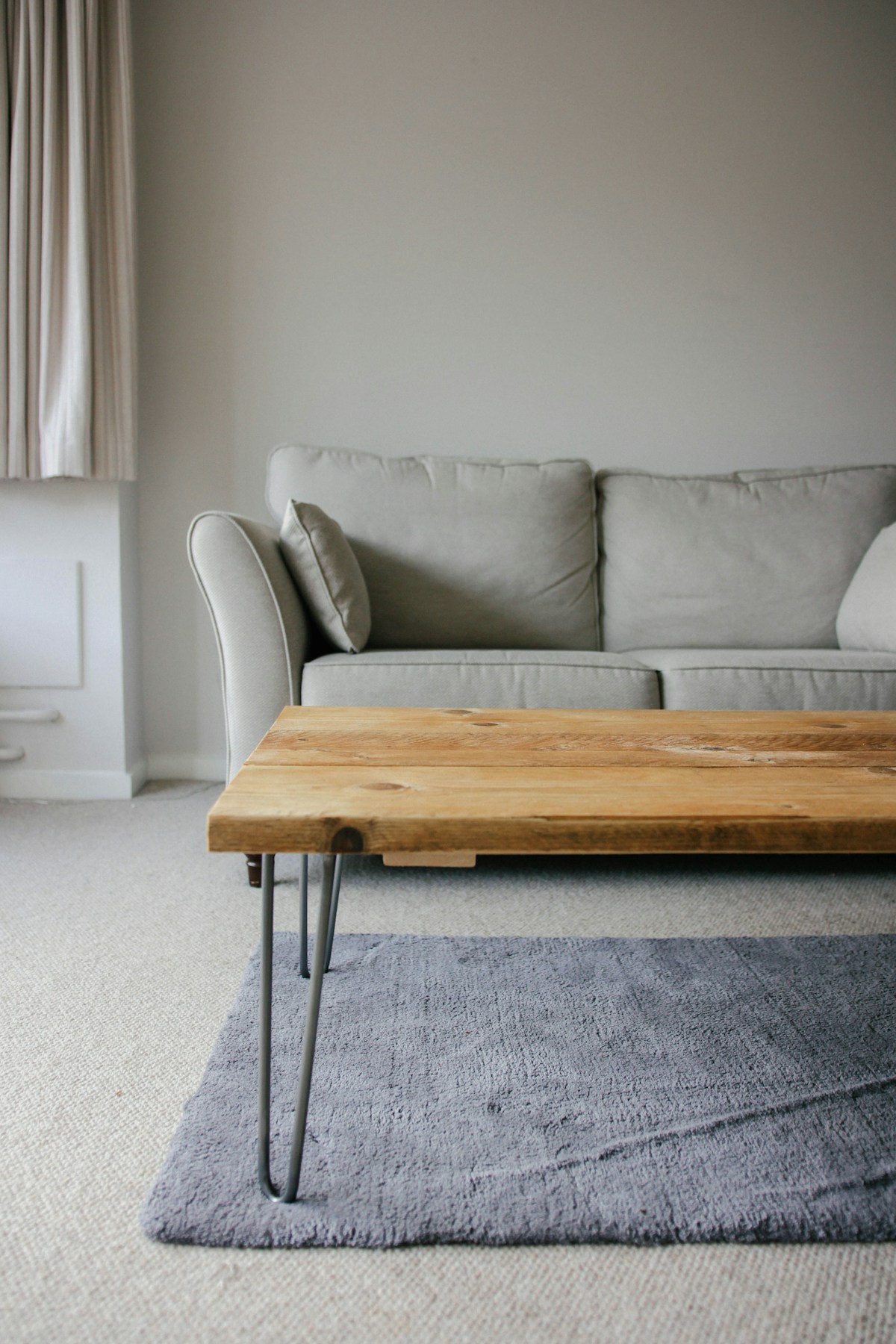 A neutral sofa and a natural wood coffee table